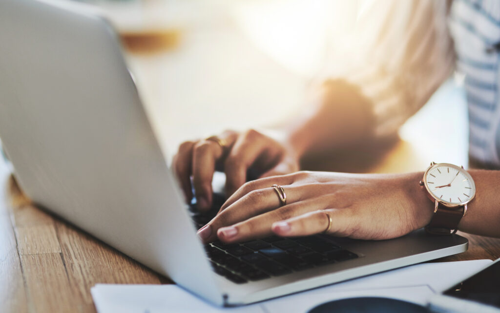 Femme d'affaires non identifiable travaillant sur un ordinateur portable dans son bureau.